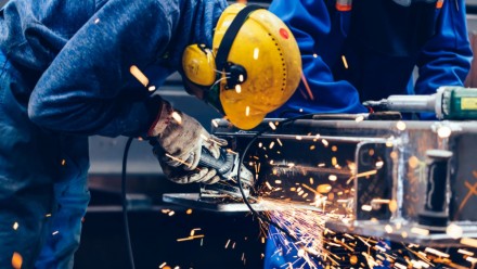 Worker grinding in a workshop. Heavy industry factory