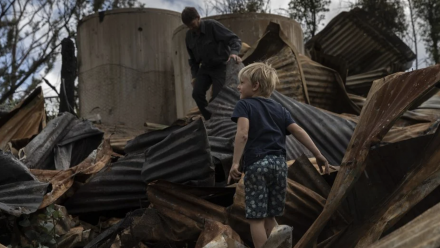 Ian Livingston and his son Sydney, 6, among the ruins of their family home, lost to the New Year’s Day bushfires in Cobargo.