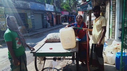 A woman in Bangladesh buys water, a new experience in previously water-abundant Bangladesh, where salt water intrusion is affecting water sources