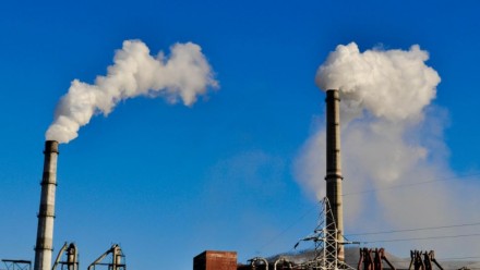 A photograph of chimneys at a coal fired power station, with a clear blue sky behind.