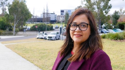 Close-up photo of Hina Aslam wearing a burgundy jacket over a black garment.