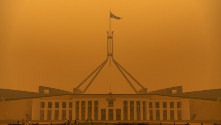 A dense orange haze of bushfire smoke covers Australian Parliament House during the 2019-20 Black Summer Bushfires.
