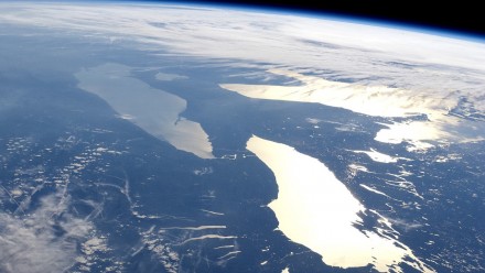 A photograph of Earth from outer space, with sunlight beaming off the ocean.