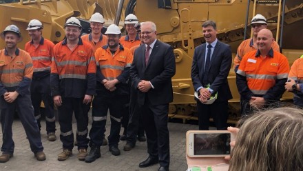 Scott Morrison in the Hunter on Tuesday, posing for a photo with workers in neon orange high-vis gear.