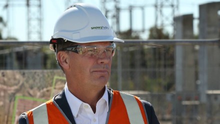 A photograph of Energy and Emissions Reduction Minister Angus Taylor, wearing a hard hat and orange reflective gear at a coal-fired power station.