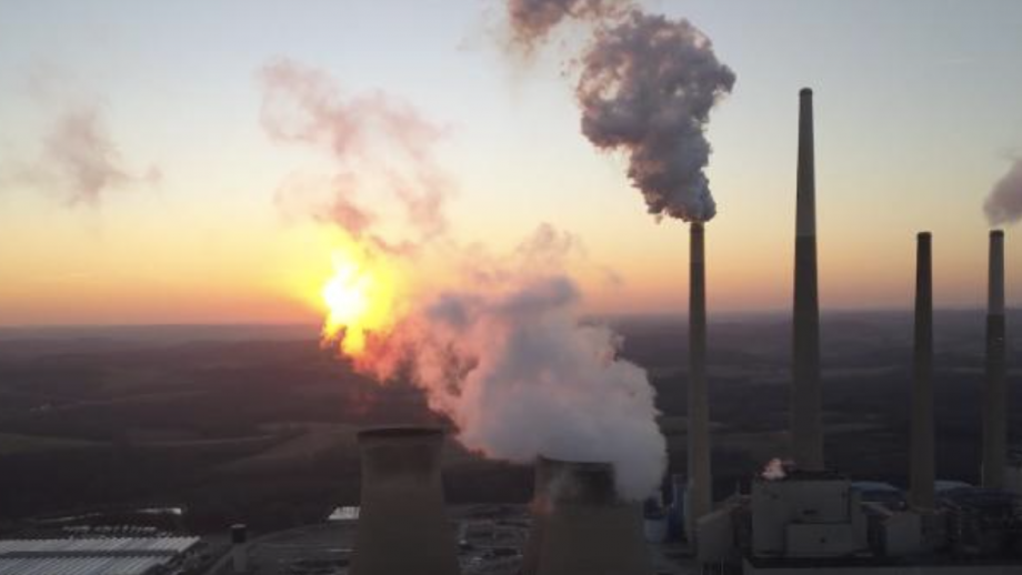 The sun sets behind a coal-fired power station.