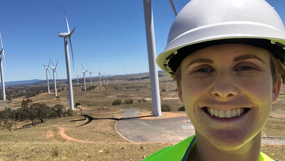 Master of Climate Change student, Caitlin Sears, standing in front of wind turbines