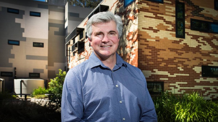 Prof Mark Howden standing in front of the Frank Fenner building at the Australian National University,