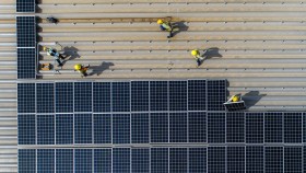 Workers installing solar on factory roof