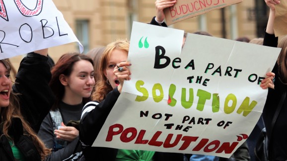 A group of young climate protesters holding placards