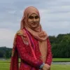 A photograph of Rahena Rannu outside, smiling and looking towards the camera.
